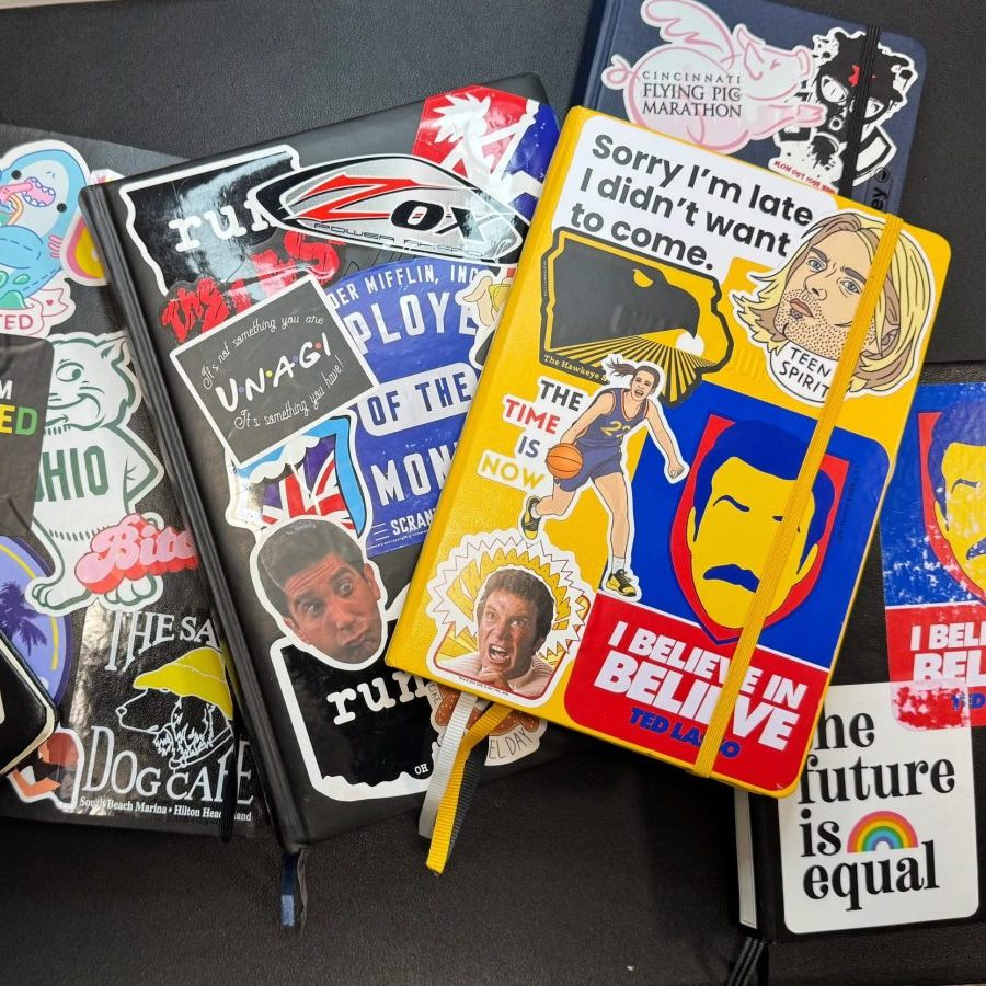 collection of stacked journals with a variety of vinyl stickers on the covers