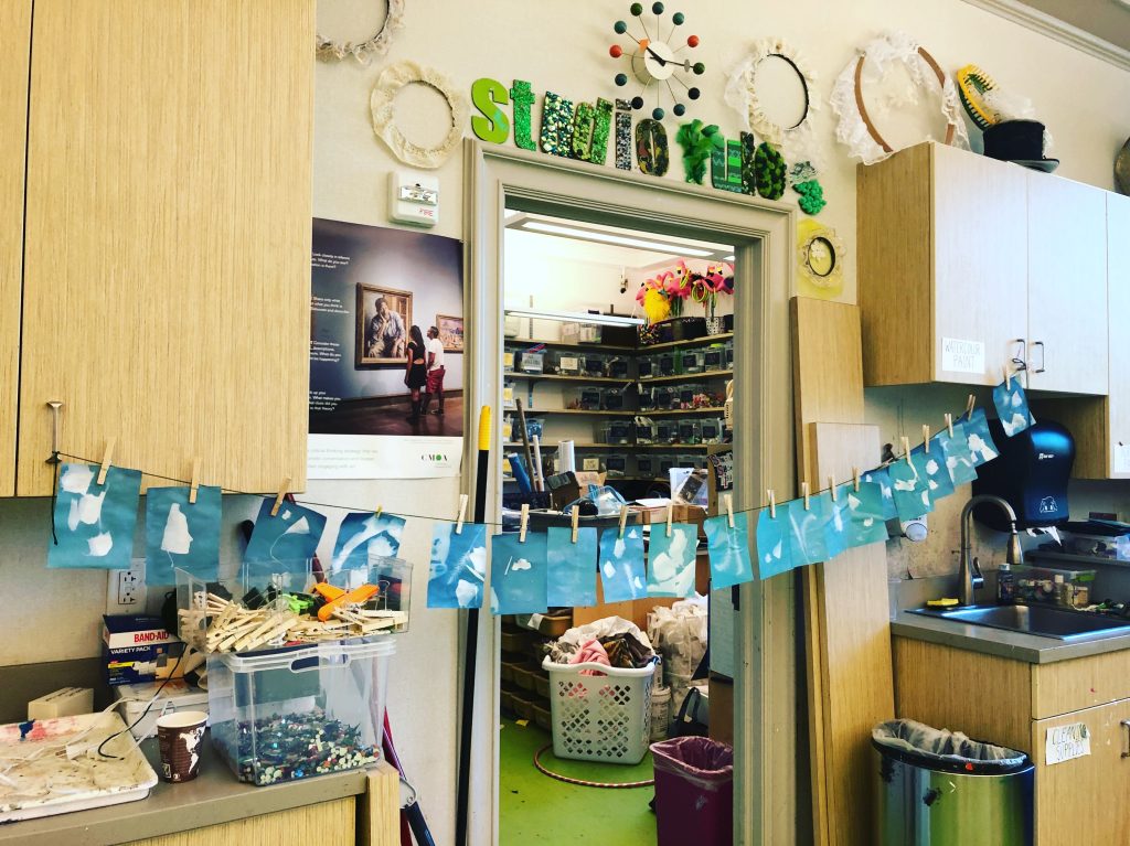 string of blue solar prints hanging to dry in an art studio